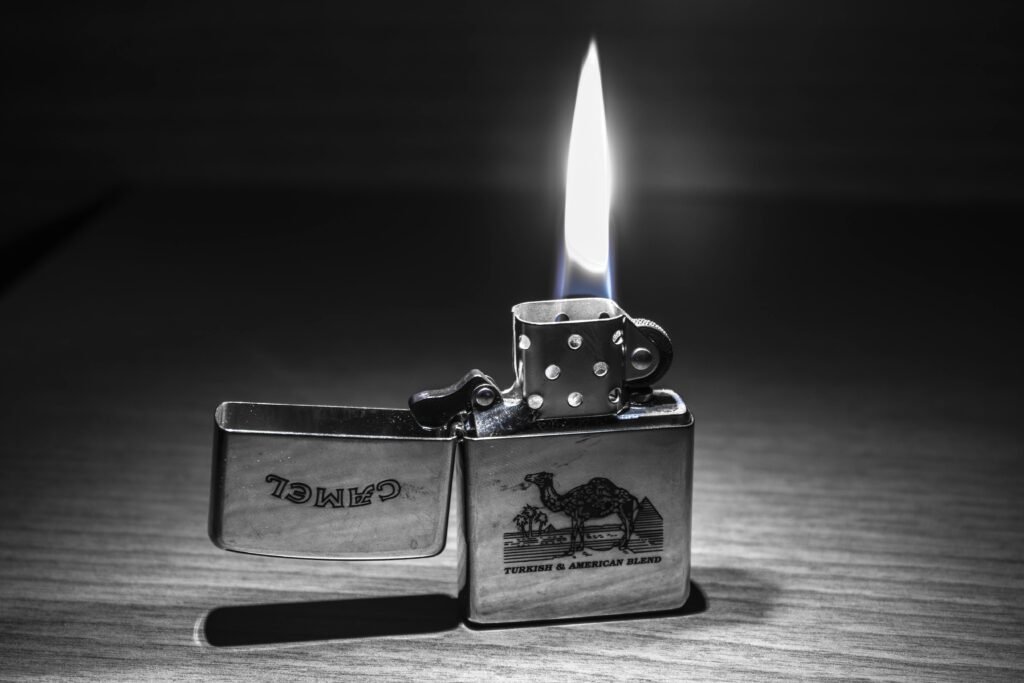 Close-up of a lit Zippo lighter with a clear flame. Perfect for themes of heat and light.
