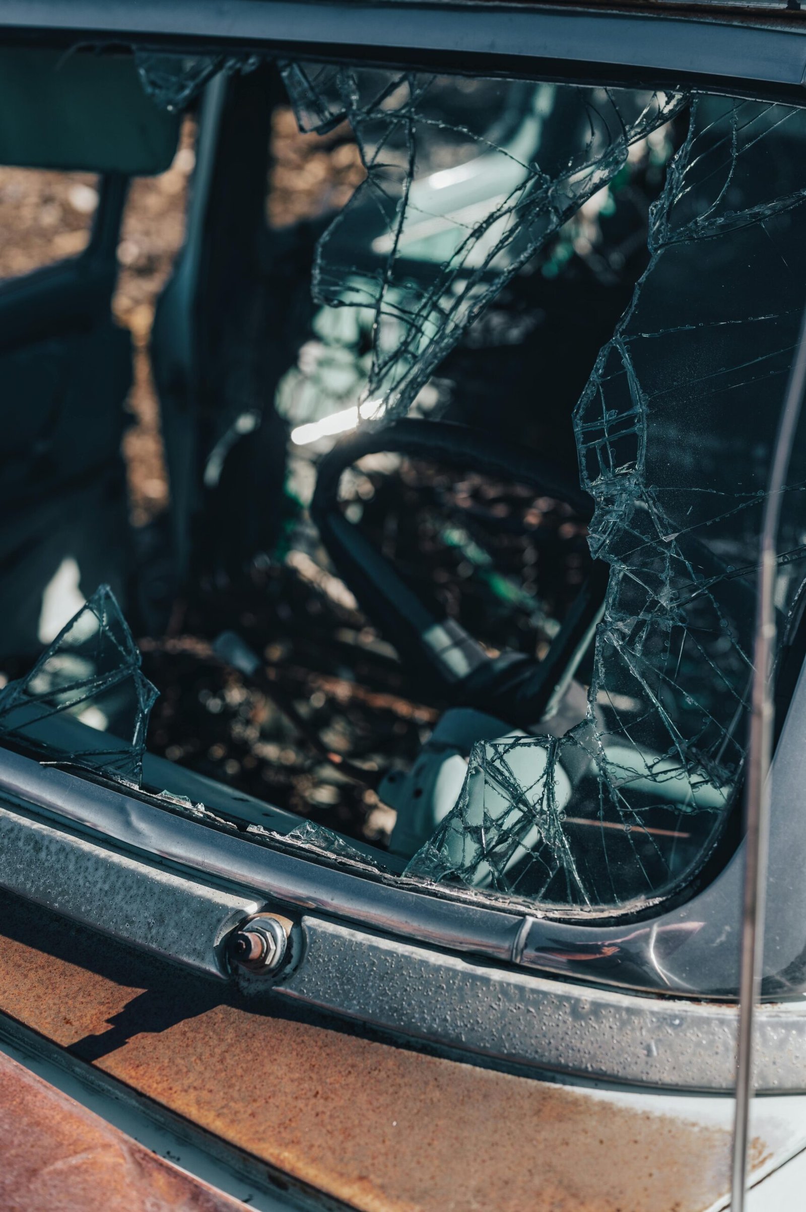 Detailed view of a shattered car window, highlighting the broken glass texture.